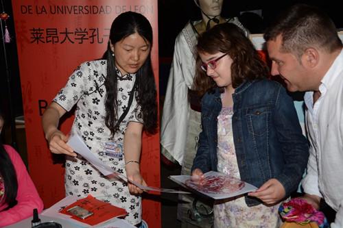 孔子学院教师向学生介绍中华传统剪纸。（西班牙《欧华报》/苏威旭